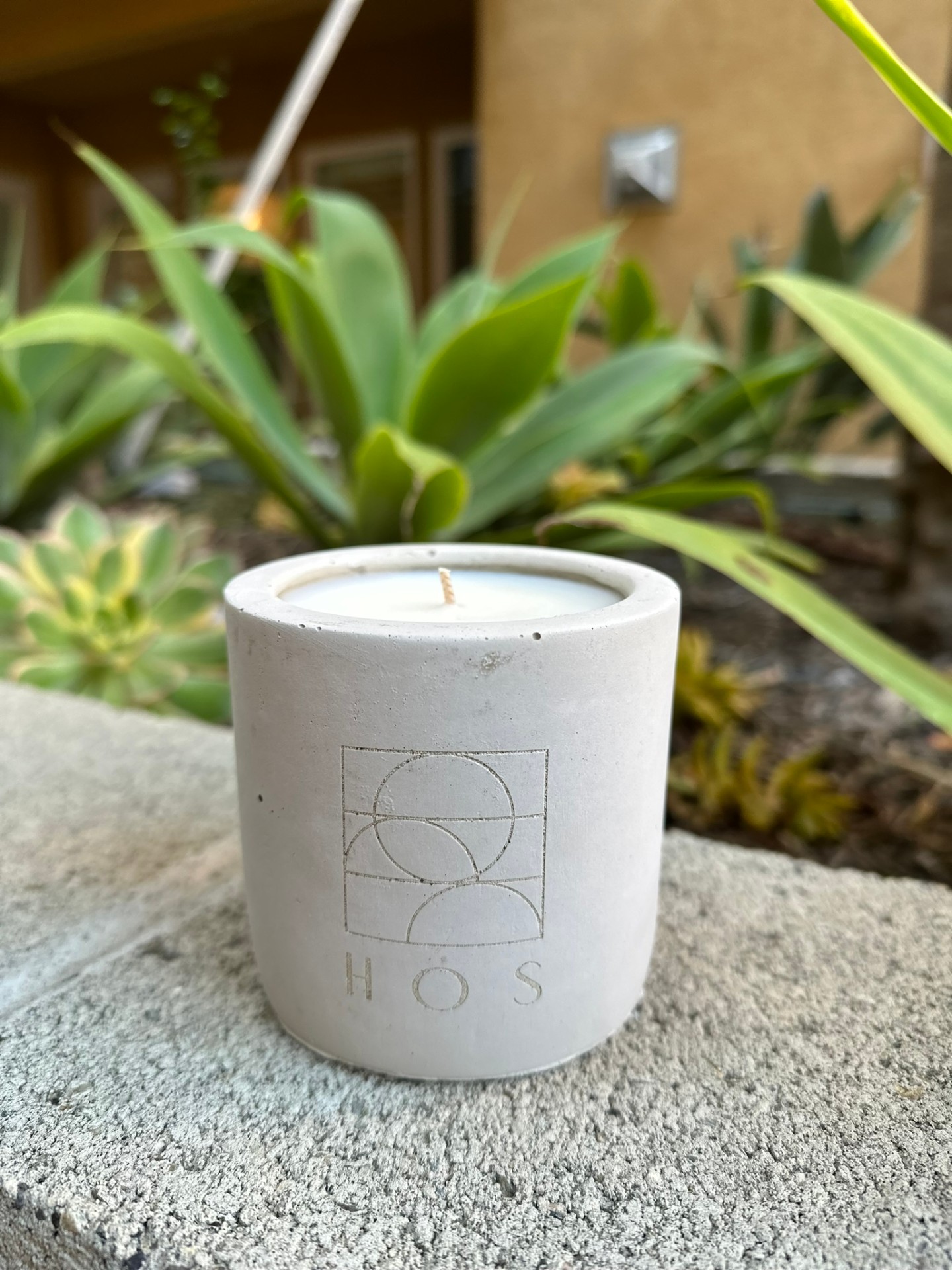 a single lit candle photographed against a soft neutral backdrop