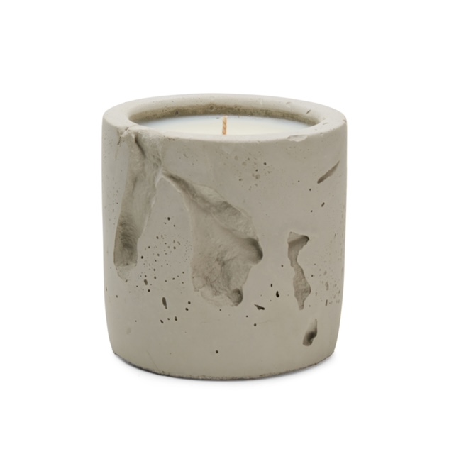 close-up of a concrete candle vessel, surface texture catching natural light