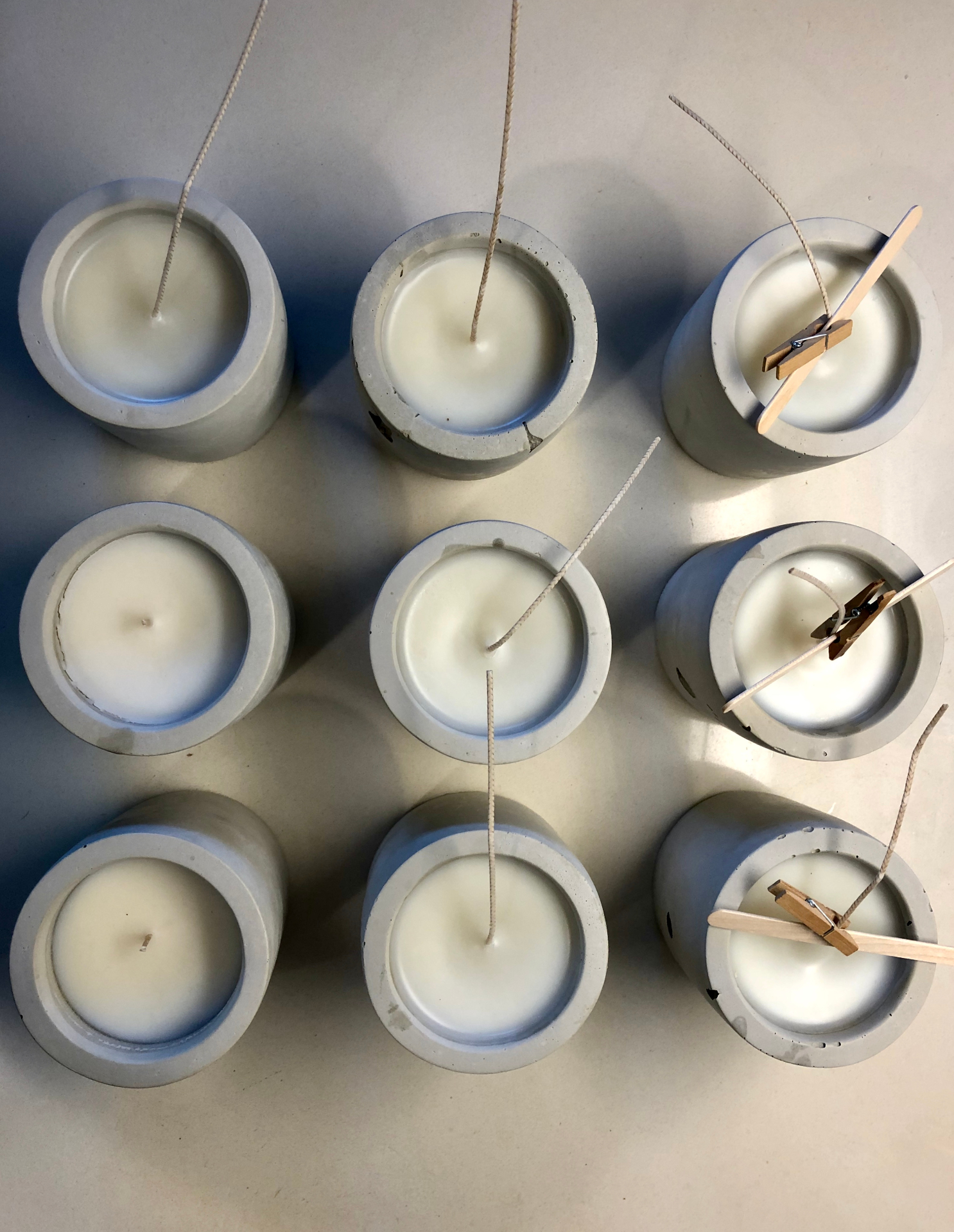 rows of freshly poured candles curing on a studio bench